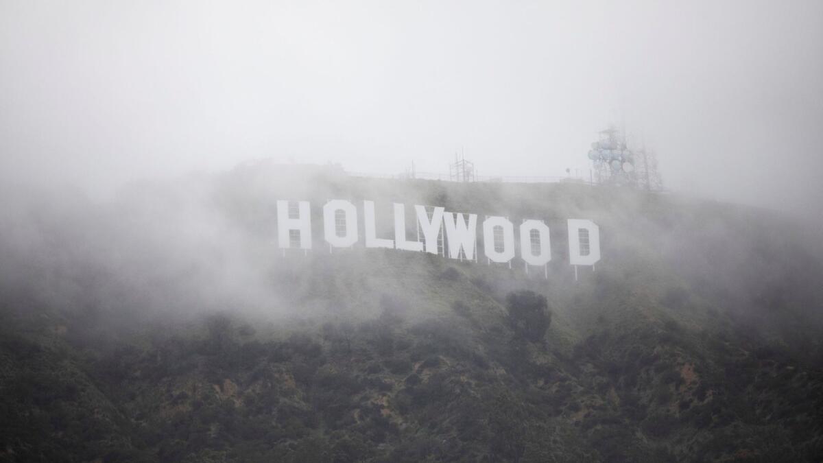 The Hollywood sign is seen through a mix of fog and dust snow during a rare cold winter storm in Los Angeles, California. — Reuters