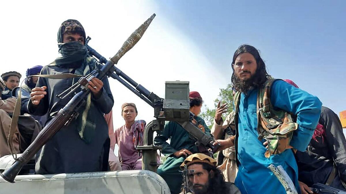Taliban fighters drive past on a street in Laghman province. Photo: AFP