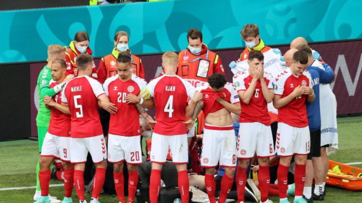 Danish players form a wall as Christian Eriksen receives medical attention after collapsing during the match against Finland. — Reuters