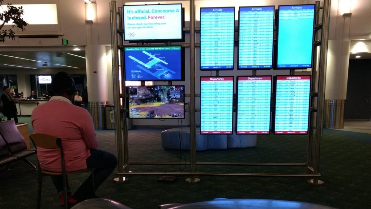 Man uses airport monitor to play video game