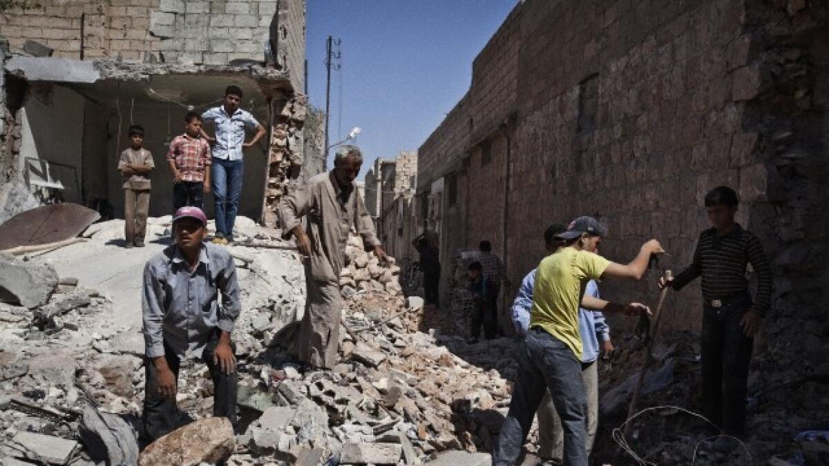 Men sift through the rubble after an air bombing in Al-Bab,Syria