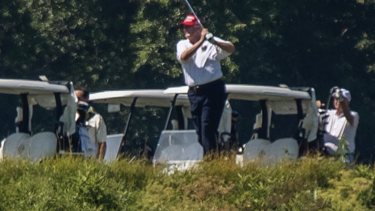 US President Donald Trump plays golf at Trump National Golf Club in Sterling, Va., as seen from the other side of the Potomac River in Darnestown. Photo: AP