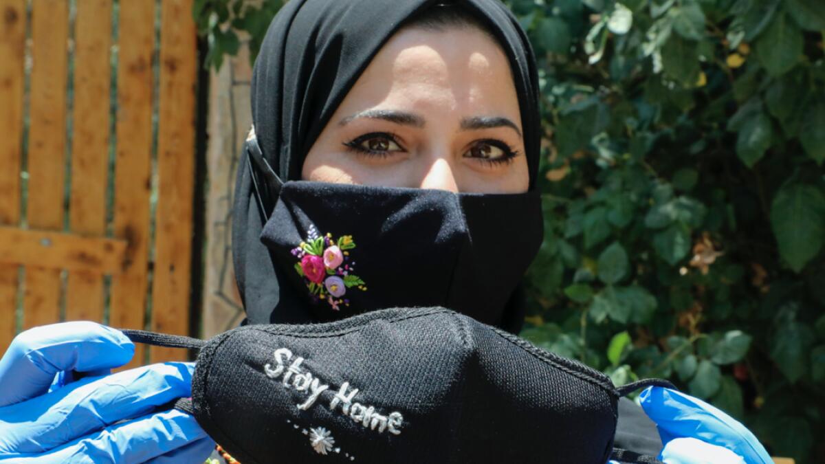 Palestinian Waad Manasra displays her hand-embroidered protective masks, sold also online, at her home in the village of Bani Naim, east of the West Bank city of Hebron. Photo: AFP