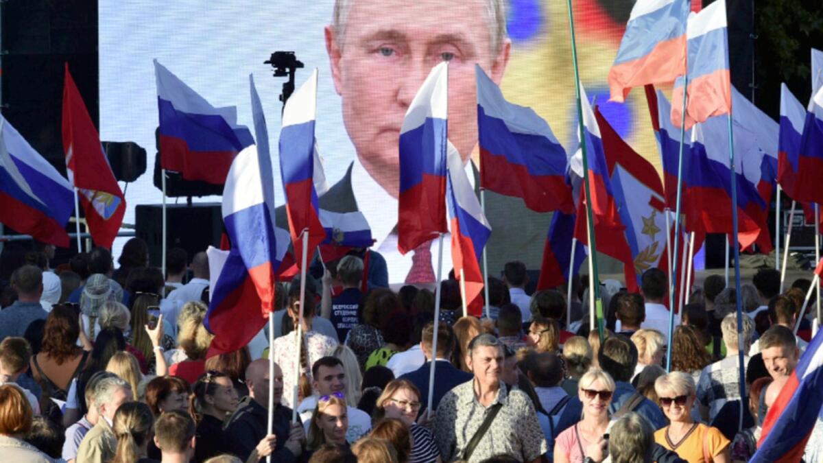 People gather in front of a large screen, to celebrate the incorporation of regions of Ukraine to join Russia in Sevastopol, Crimea. — AP