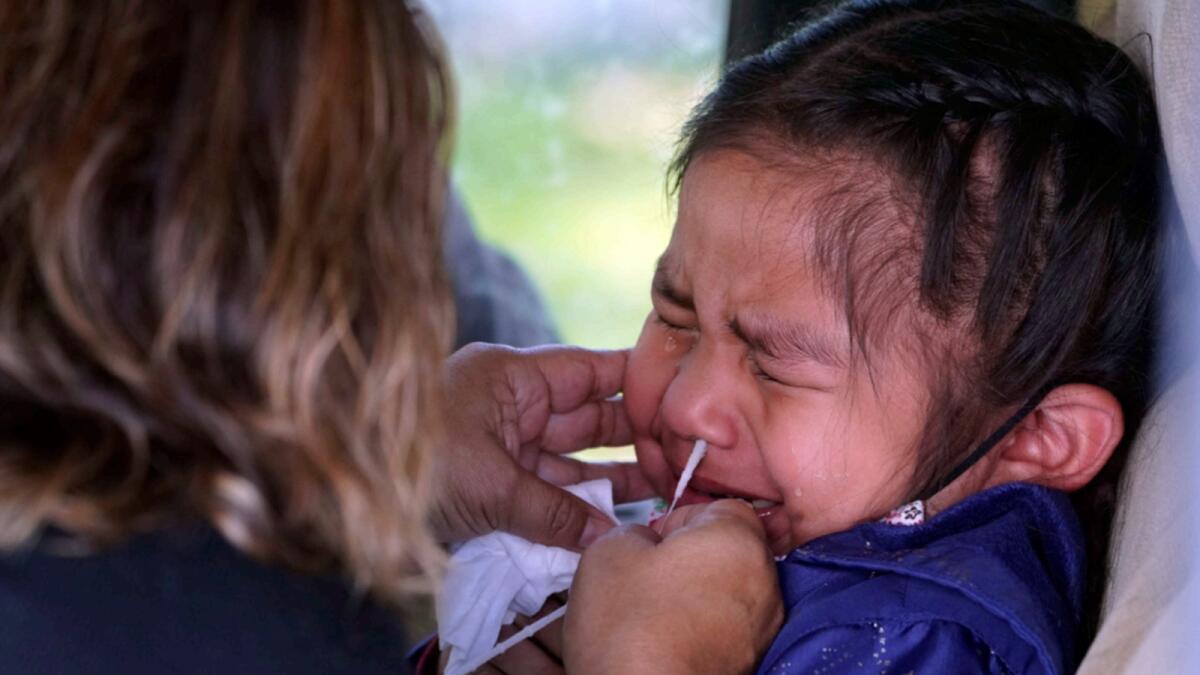 Sophie Gazmin, 4, grimaces as she's tested for Covid-19 by her mother Eligiia Parra in California. — AP