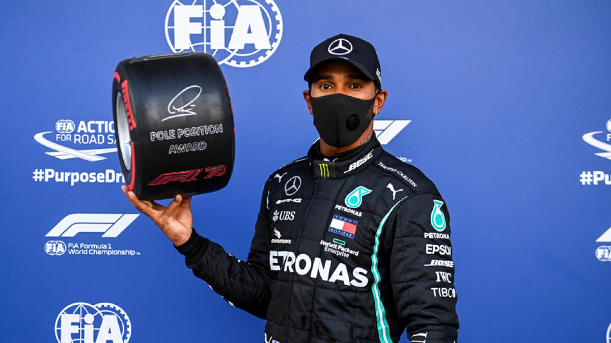 Mercedes' Lewis Hamilton celebrates with the Pirelli Pole Position Award. - Reuters