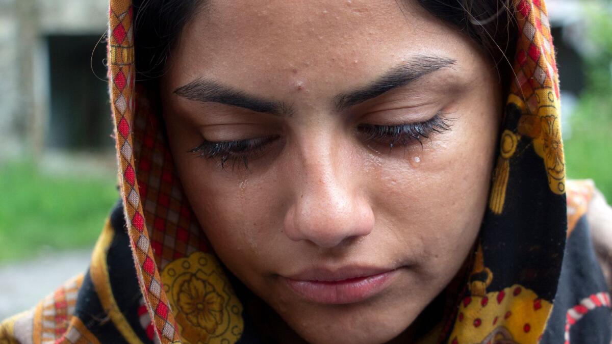 A woman from Afghanistan cries in the village of Bosanska Bojna, Bosnia, on Saturday.