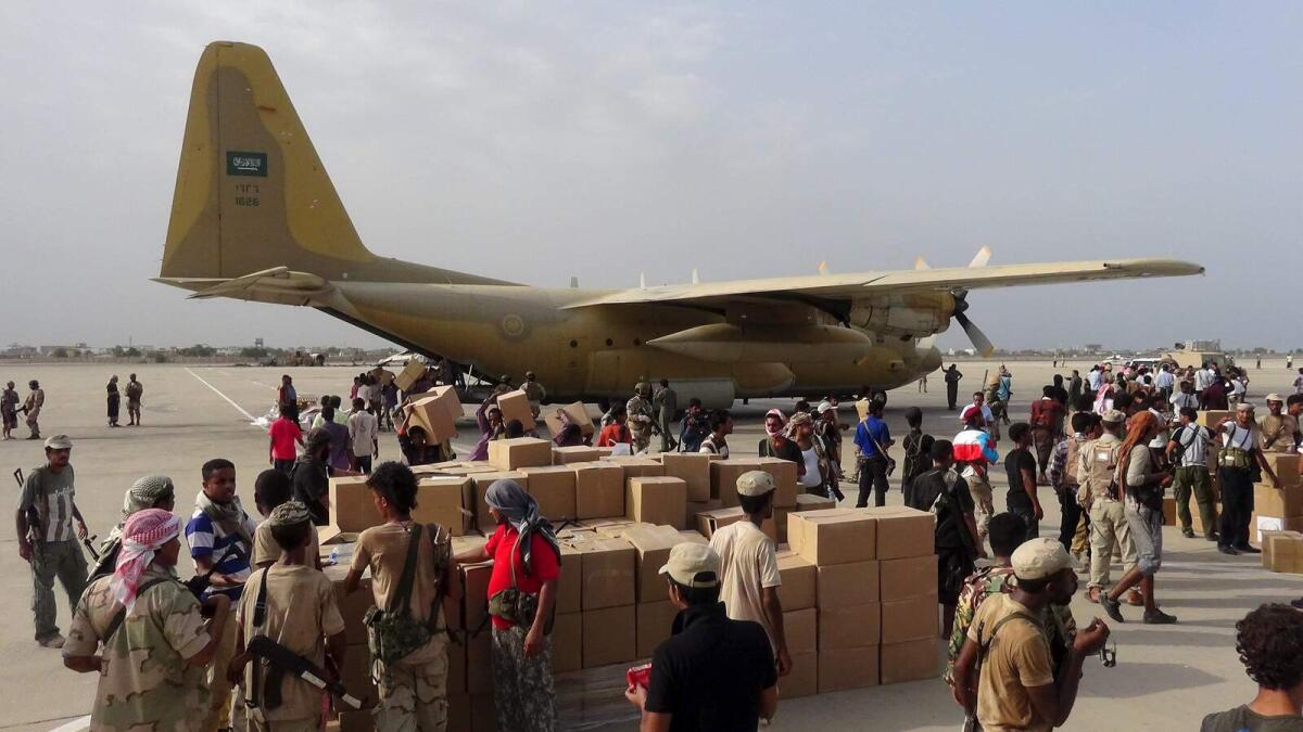 Workers and Southern Resistance fighters unload an aid shipment from a Saudi military cargo plane at the international airport of Yemen's southern port city of Aden July 23, 2015.