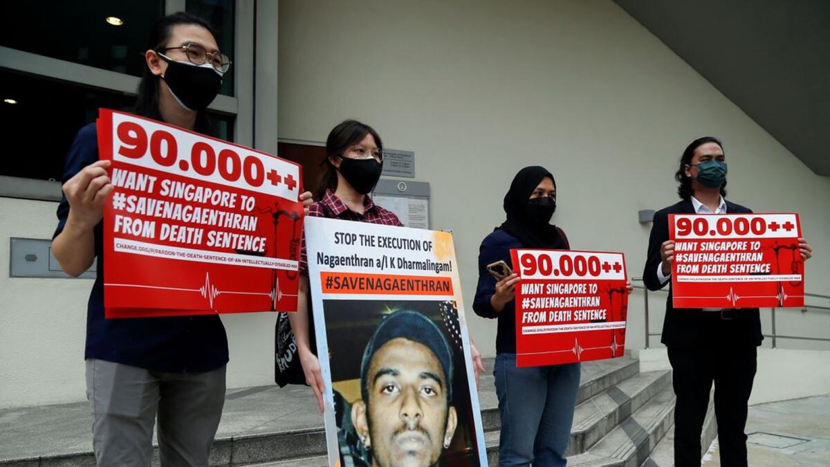 Activists hold placards and a poster against the execution of Nagaenthran Dharmalingam, who was sentenced to death for drug trafficking in Singapore. – Reuters