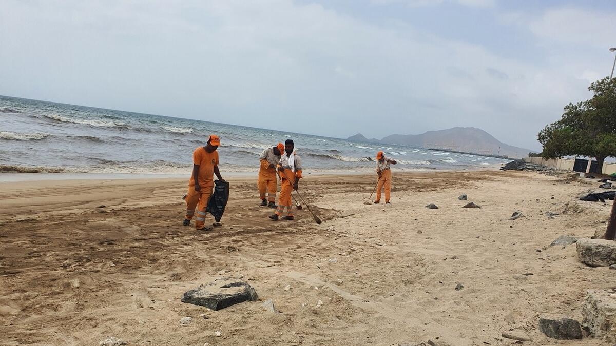 Workers clean up the beach