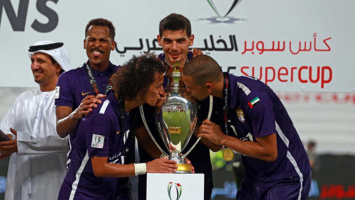 Al Ain players celebrate with the trophy after defeating Al Nasr in the Arabian Gulf Super Cup match.