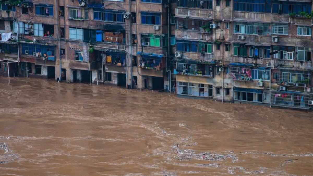 Flood water flow past a residential building in Qijiang District of Chongqing Municipality. A wide swath of southern China braced on Sunday, July 5, 2020 for more seasonal rains and flooding that state media said has already left more than 120 people dead or missing this year. (Photo: Chen Xingyu/Xinhua via AP)