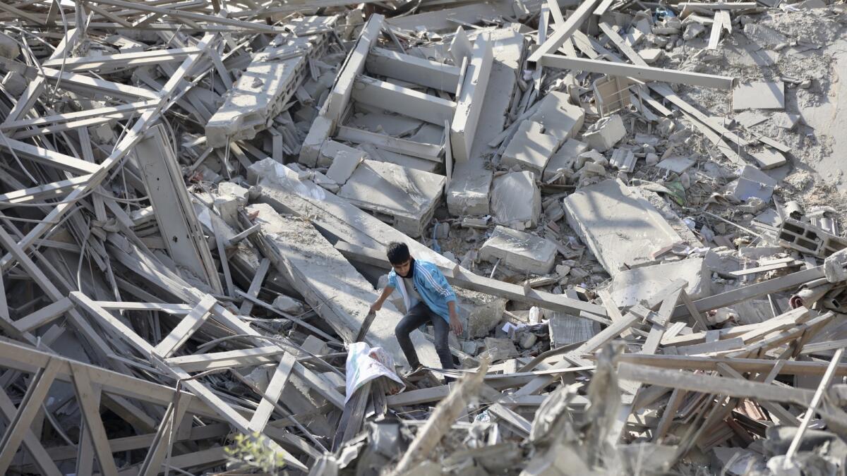 Palestinians walk through the destruction left by the Israeli air and ground offensive on the Gaza Strip in Gaza City. — AP