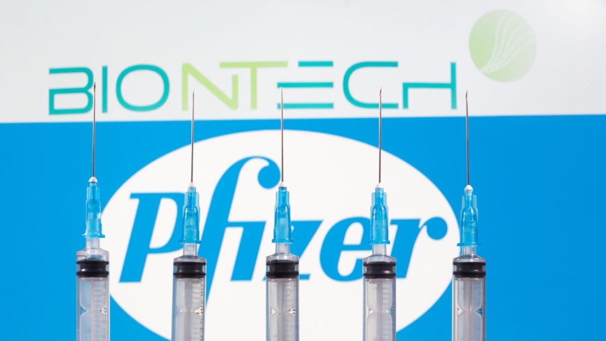 Syringes are seen in front of displayed Biontech and Pfizer logos in this illustration taken November 10, 2020.