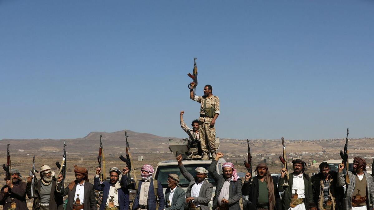 Houthi fighters and tribal supporters hold up their firearms during a protest against US-led strikes on Houthi targets, near Sanaa. — Reuters