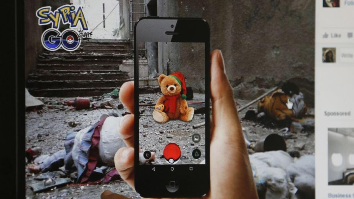 A journalist looks at a montage by a Syrian artist, using the international frenzy over the Pokemon Go game to draw new attention to the battle-scarred country, in Beirut 