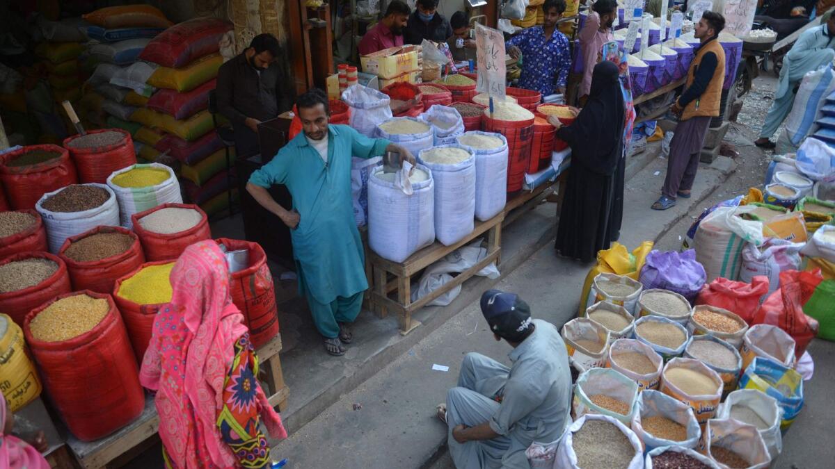 People buy pulses and grains at a wholesale market in Karachi. The consumer price index rose 27.5 per cent year-on-year basis in January, its highest in nearly half a century. — AFP