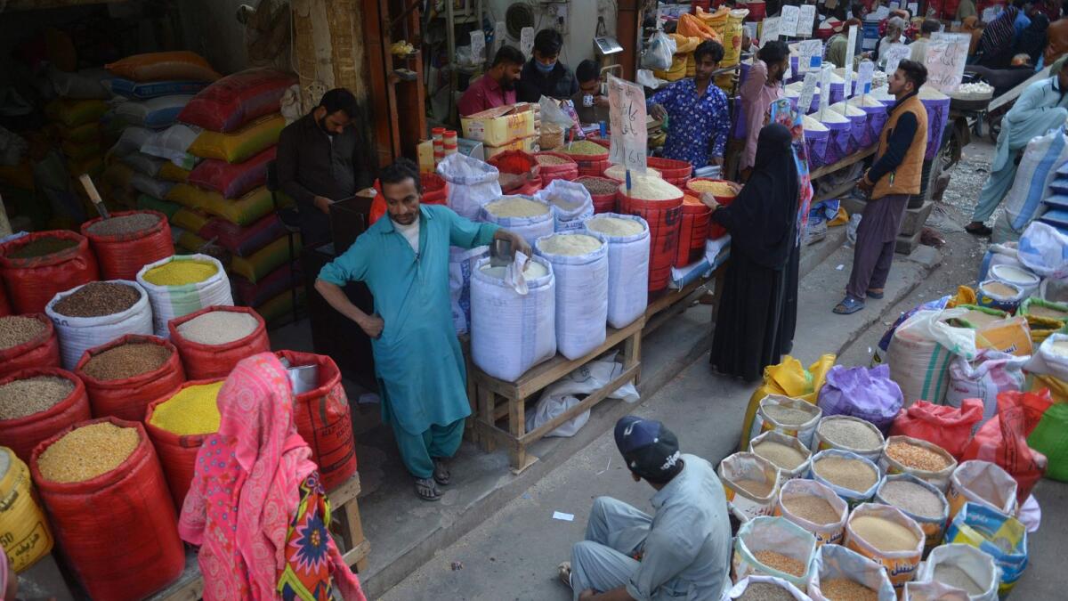 People buy pulses and grains at a wholesale market in Karachi. Inflation has risen to a 48-year high in crisis-hit Pakistan, where the International Monetary Fund is visiting for urgent talks. - AFP