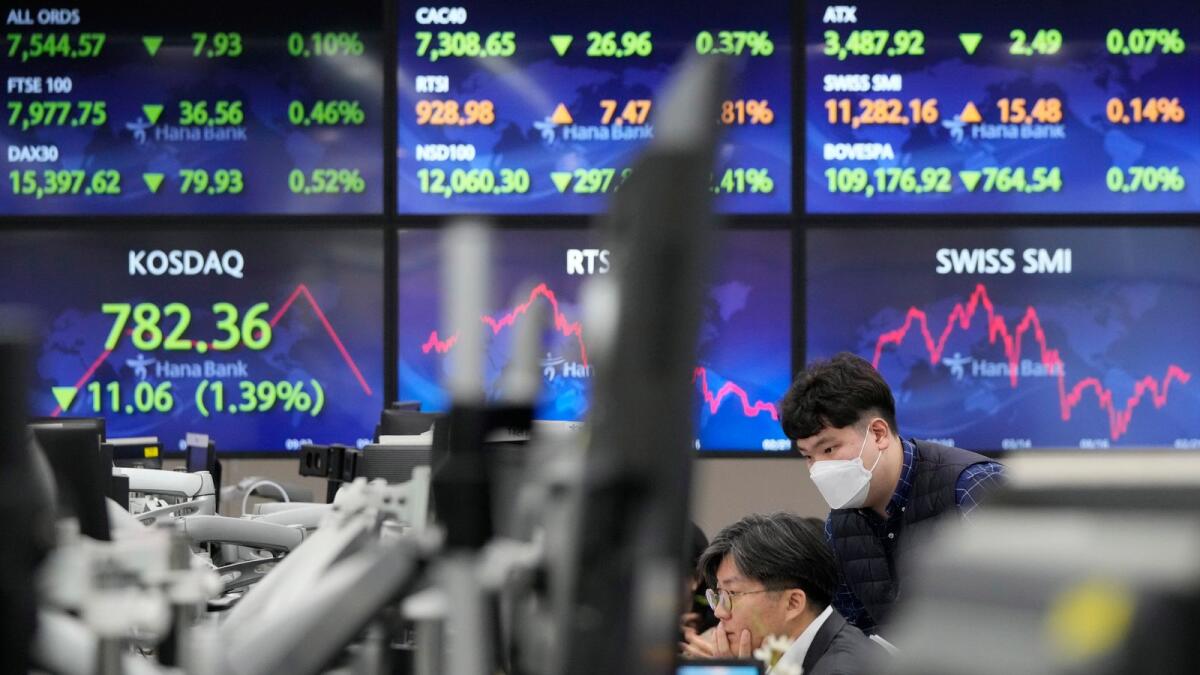 Currency traders watch monitors at the foreign exchange dealing room of the KEB Hana Bank headquarters in Seoul, on Wednesday. Asian shares declined Wednesday after stocks tumbled on Wall Street as worries persist about higher interest rates and their tightening squeeze on the global economy. - AP