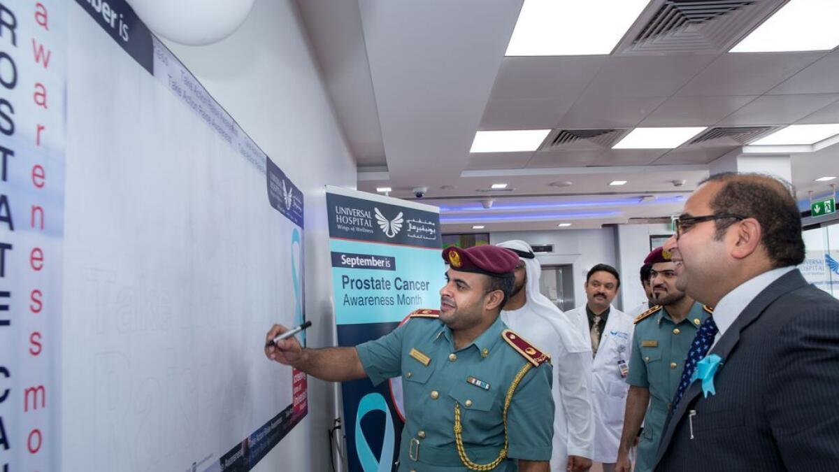 Major Dr Younis Yaaqoup Al Yaarobi writes on the notice board as Universal Hospital founder and managing director Dr Shabeer Nellikode looks on.