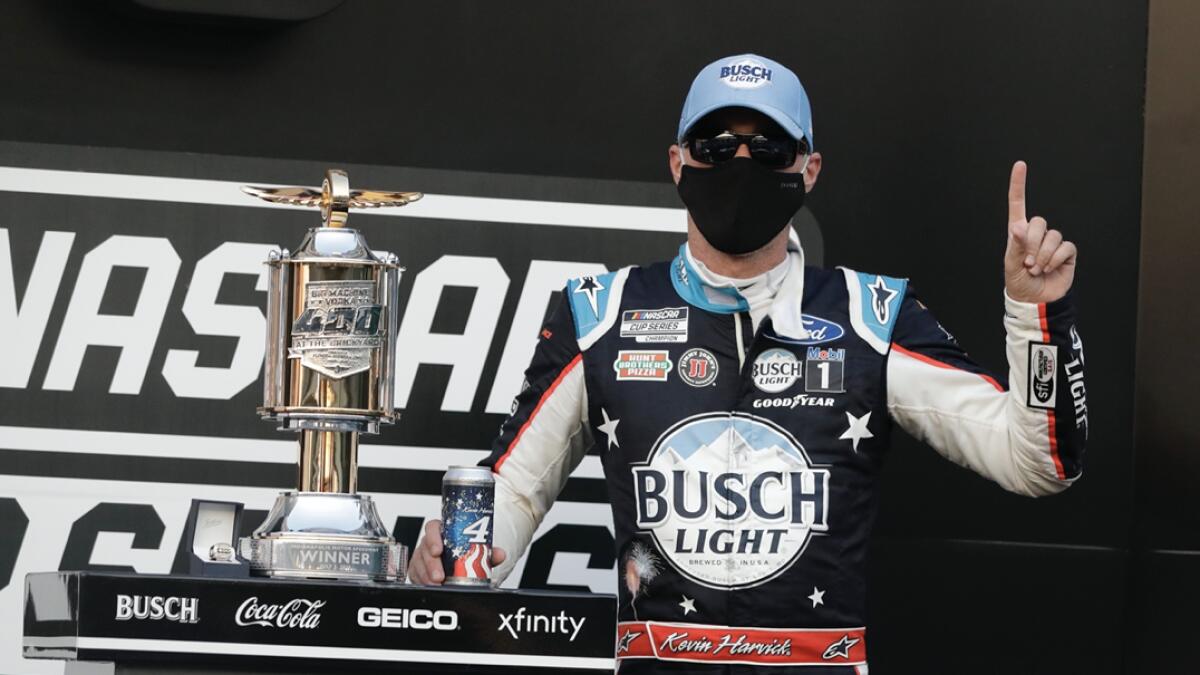 Race driver Kevin Harvick celebrates after winning the NASCAR Cup Series auto race at Indianapolis Motor Speedway in Indianapolis. AP
