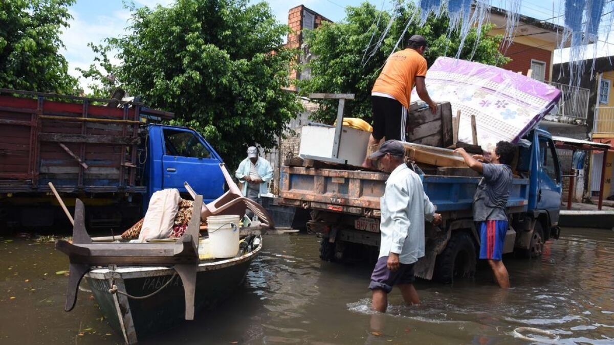 Locals recover belongings at a flooded neighbourhood in Asuncion, Paraguay.
