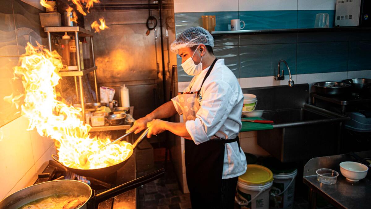 A cook prepares a dish called 'Lomo Saltado' (Stir-fried Beef) at the kitchen of a restaurant in Lima, amid the new coronavirus pandemic. The restaurants of Peru, a country with world famous gastronomy, reopened their doors Monday after four months of confinement due to the new coronavirus pandemic. Photo: AFP