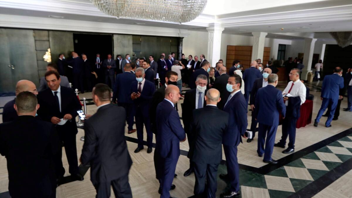 Lebanese lawmakers and ministers wait in the foyer due to a power outage for a meeting to confirm Lebanon's new government. — AP