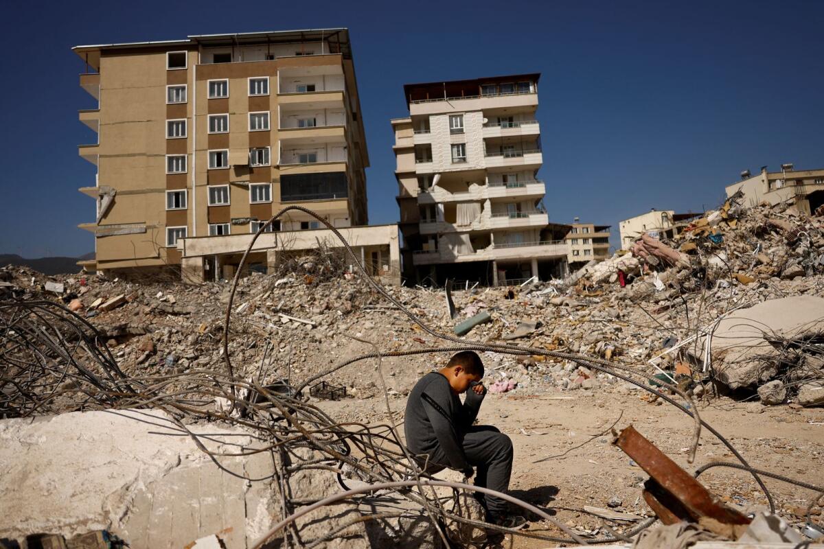 Saltuk Arslan, 9-year-old, sits while visiting the remains of his home. Photo: reuters