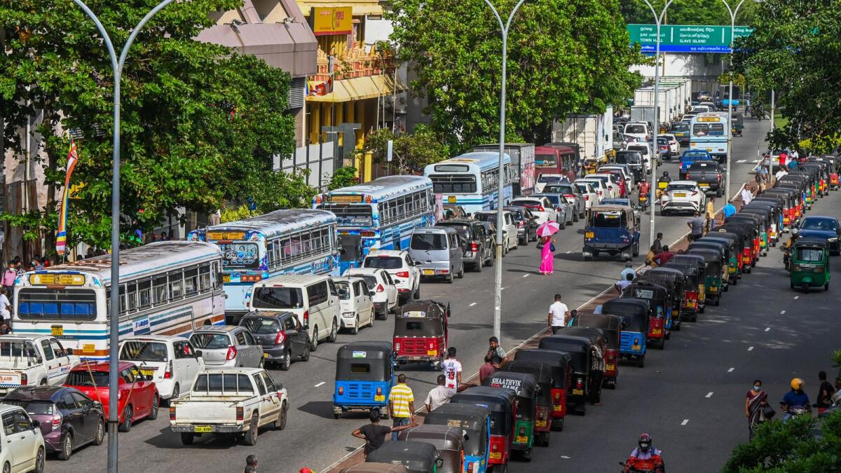 Motorists queue along a street to buy fuel at Ceylon petroleum corporation fuel station in Colombo on May 18, 2022. Photo: AFP