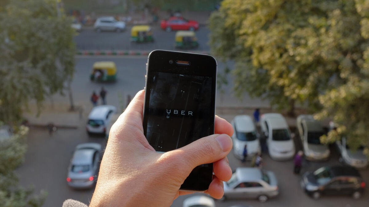 The Uber smartphone app seen over a parking lot in New Delhi. — AFP file