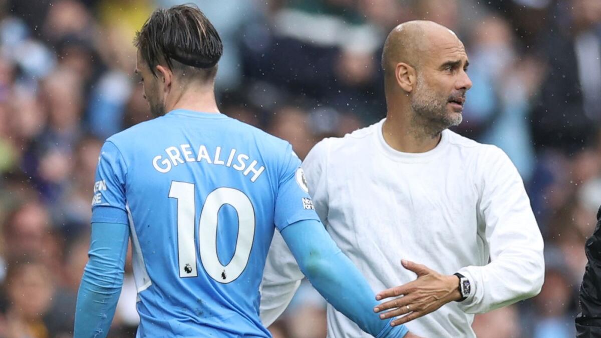 Manchester City's Jack Grealish with manager Pep Guardiola after being substituted during the match against Norwich City. — Reuters
