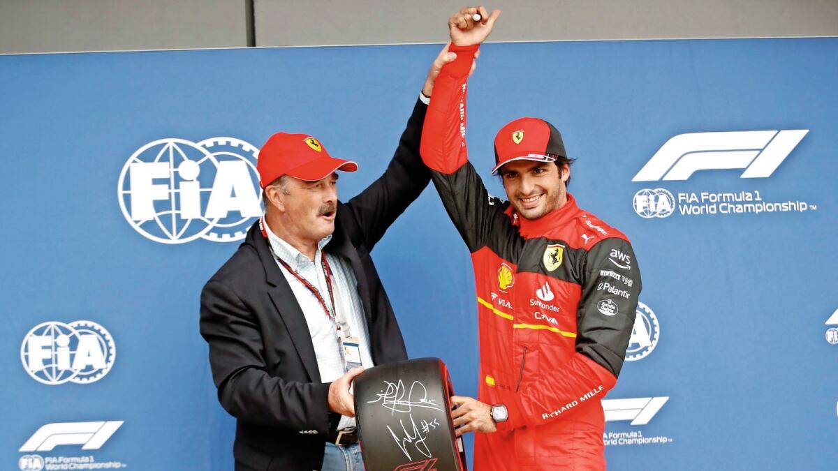 Ferrari's Carlos Sainz celebrates after taking pole position alongside former British F1 champion Nigel Mansell. — Reuters