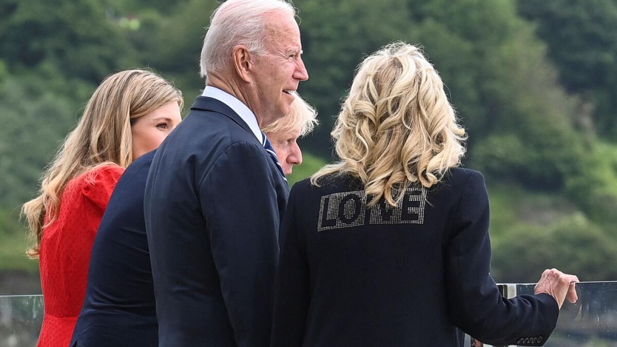 Britain's Prime Minister Boris Johnson (2R), his wife Carrie Johnson (L) and US President Joe Biden and US First Lady Jill Biden, wearing a jacket bearing the words 'love', look out over the sea, prior to a meeting at Carbis Bay, Cornwall, on Thursday.