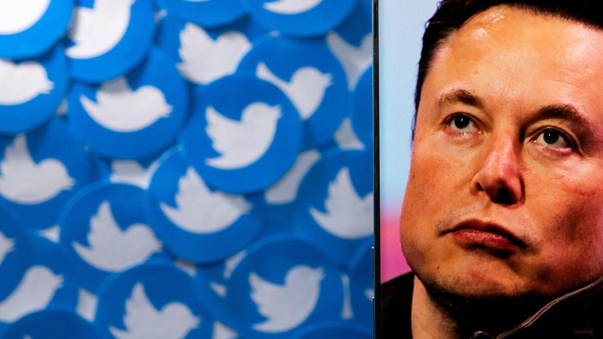 An image of Elon Musk is seen on a smartphone placed on printed Twitter logos. Musk claimed that Twitter’s monetizable daily active users are 65 million lower than what the company has touted. Twitter has said it stands by its disclosures. — Reuters file photo
