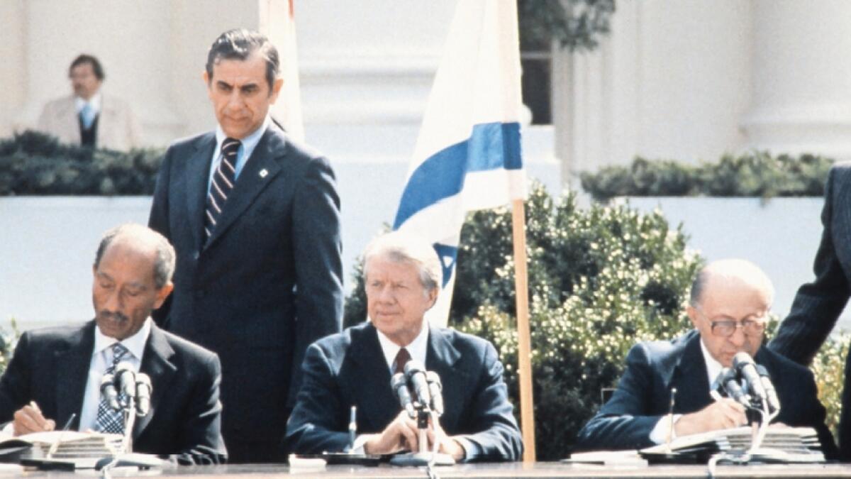 NEW ERA: Former Egyptian president Anwar Sadat and ex-Israeli premier Menachem Begin sign a peace treaty on March 26, 1979 . Then US president Jimmy Carter is also seen. — AFP, Reuters
