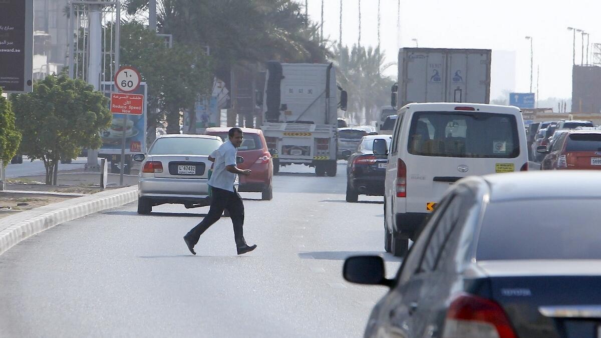 Man crossing the road from Al Tawoon Street in Sharjah.- Photo by M.Sajjad