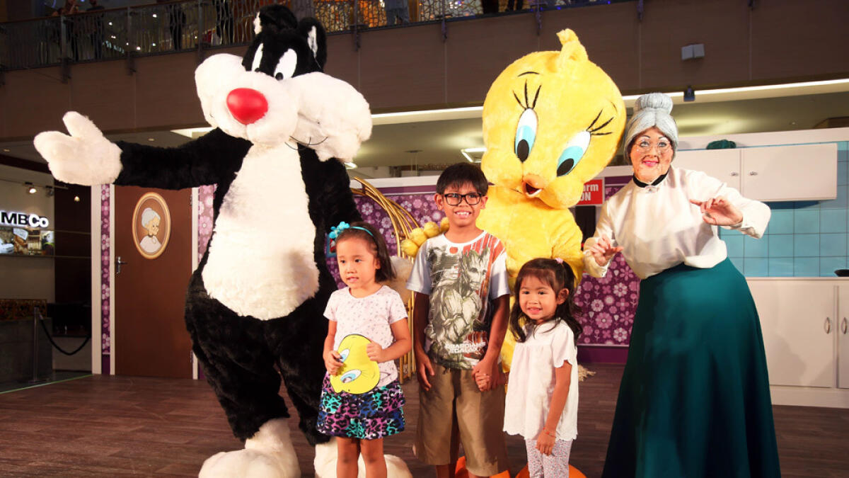 The Looney Tunes characters Sylvester, Tweety Bird and Granny pose for a photo with the kids at Mirdiff City Centre. -Photo by Dhes Handumon/ Khaleej Times