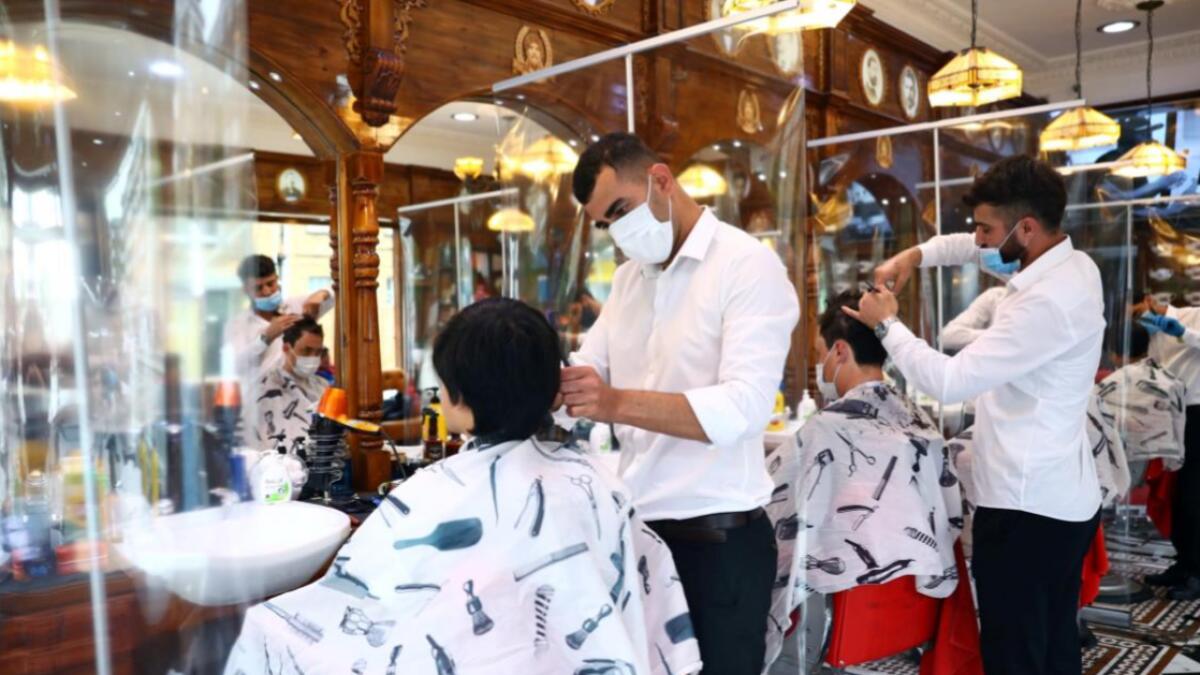 Men have their hair cut at Savvas Barbers as it reopened following the outbreak of the coronavirus disease (Covid-19), in London, Britain. Photo: Reuters(Research done by Fakhar Ul Islam/KT)
