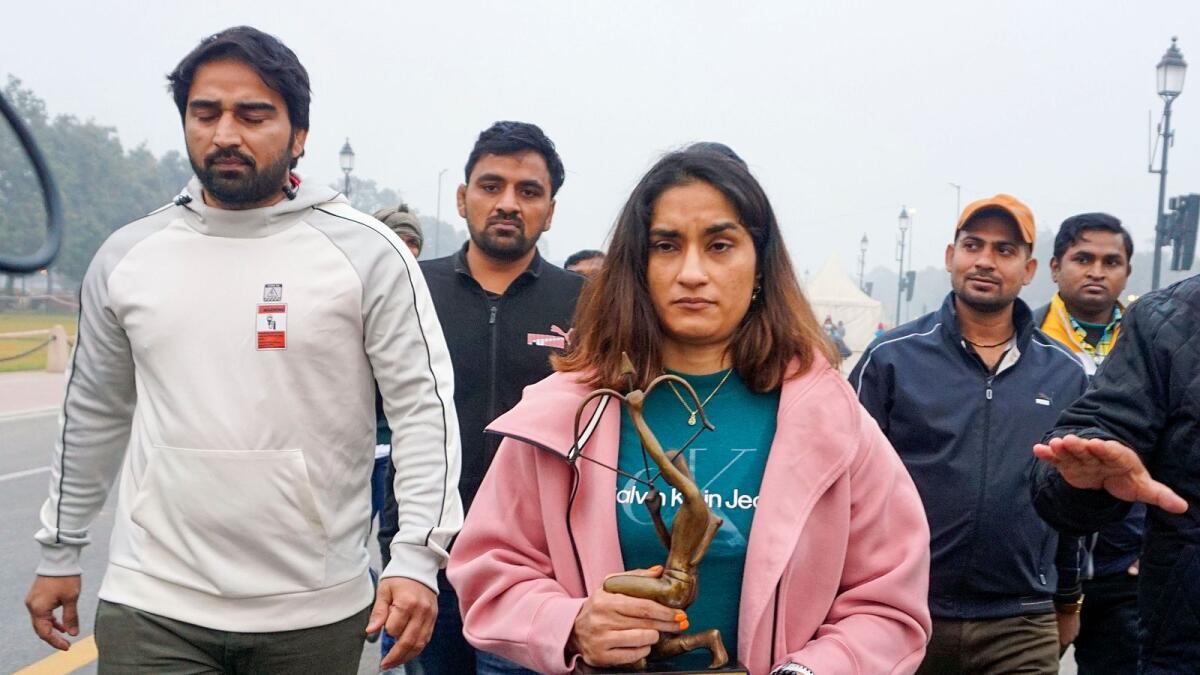 Wrestler Vinesh Phogat walks with her Arjuna and Khel Ratna awards before leaving them on a pavement near the prime minister's office. — PTI
