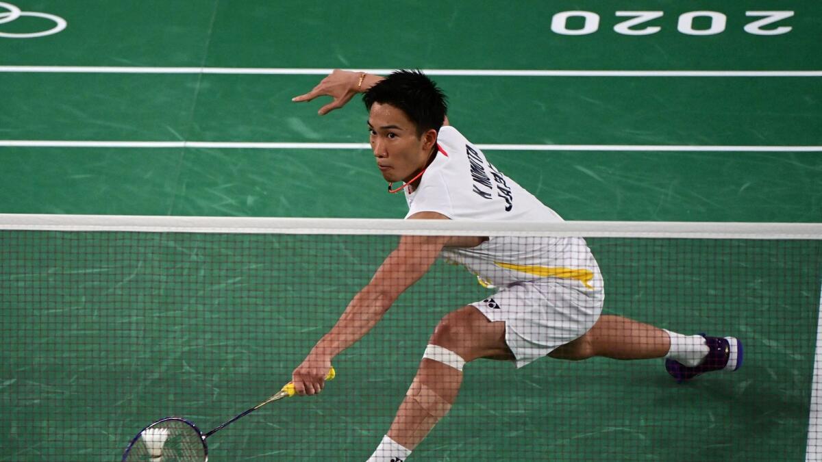 Japan's Kento Momota hits a shot to USA's Timothy Lam in their men's singles badminton group stage match. — AFP