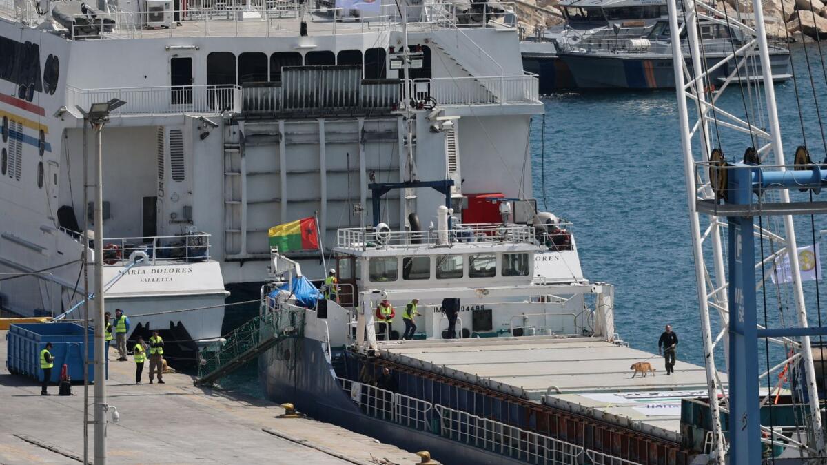 A police officer uses a sniffer dog to inspect the cargo ship loaded with humanitarian aid for Gaza in the port of Larnaca, Cyprus on Saturday. Photo: Reuters